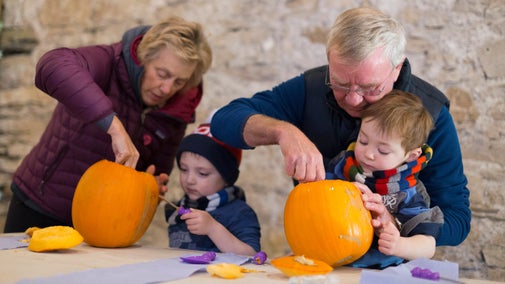 Children and adults carve pumpkins at Sizergh, Cumbria